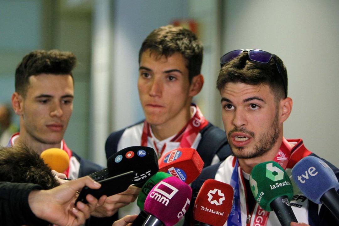 El atleta Óscar Husillos atiende a la prensa a su llegada este lunes al aeropuerto de Madrid Barajas Adolfo Suárez. Junto a él Lucas Búa (c) y Manuel Guijarro (i)