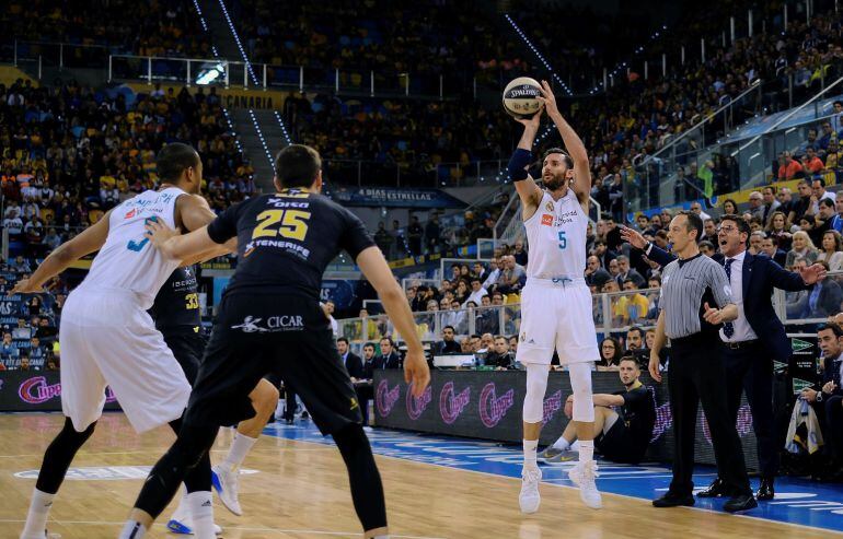El ala-pivot del Iberostar Tenerife Rosco Allen (c), marca al ala-pivot del Real Madrid, Anthony Randolph (i), mientras su compañero, el alero Rudy Fernández, lanza un triple, durante la primera semifinal de la Copa del Rey de Baloncesto, que ambos equipo