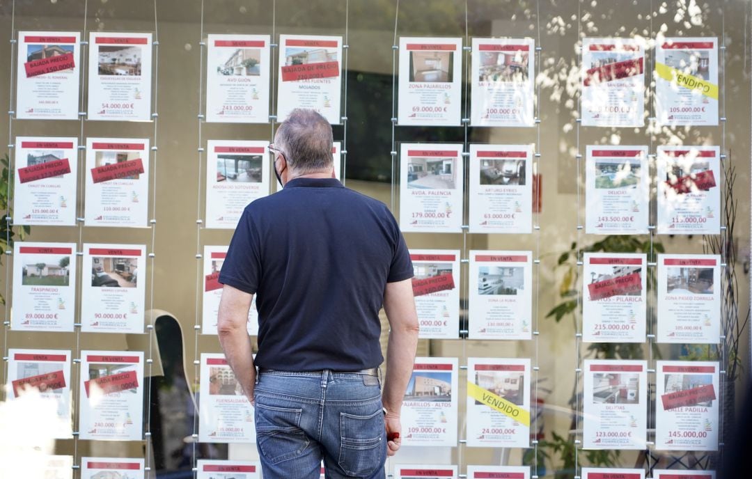 Un hombre observa los anuncios de pisos en venta y alquiler en una inmobiliaria