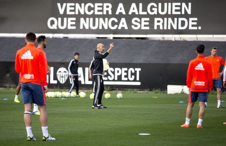 GRA140. VALENCIA, 28032016. Uno de los técnicos de la planilla valencianista, Pako Ayestarán (centro), da indicaciones a los jugadores del primer equipo que esta tarde han participado en el primer entrenamiento tras las vacaciones de Semana Santa. EFEManu