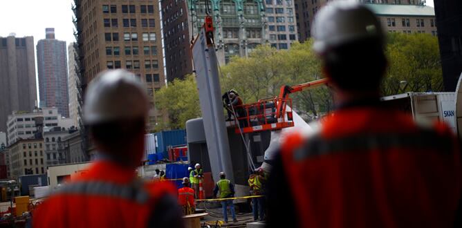 Dos trabajadores observan como se coloca la primera piedra del proyecto Calatrava en Nueva York