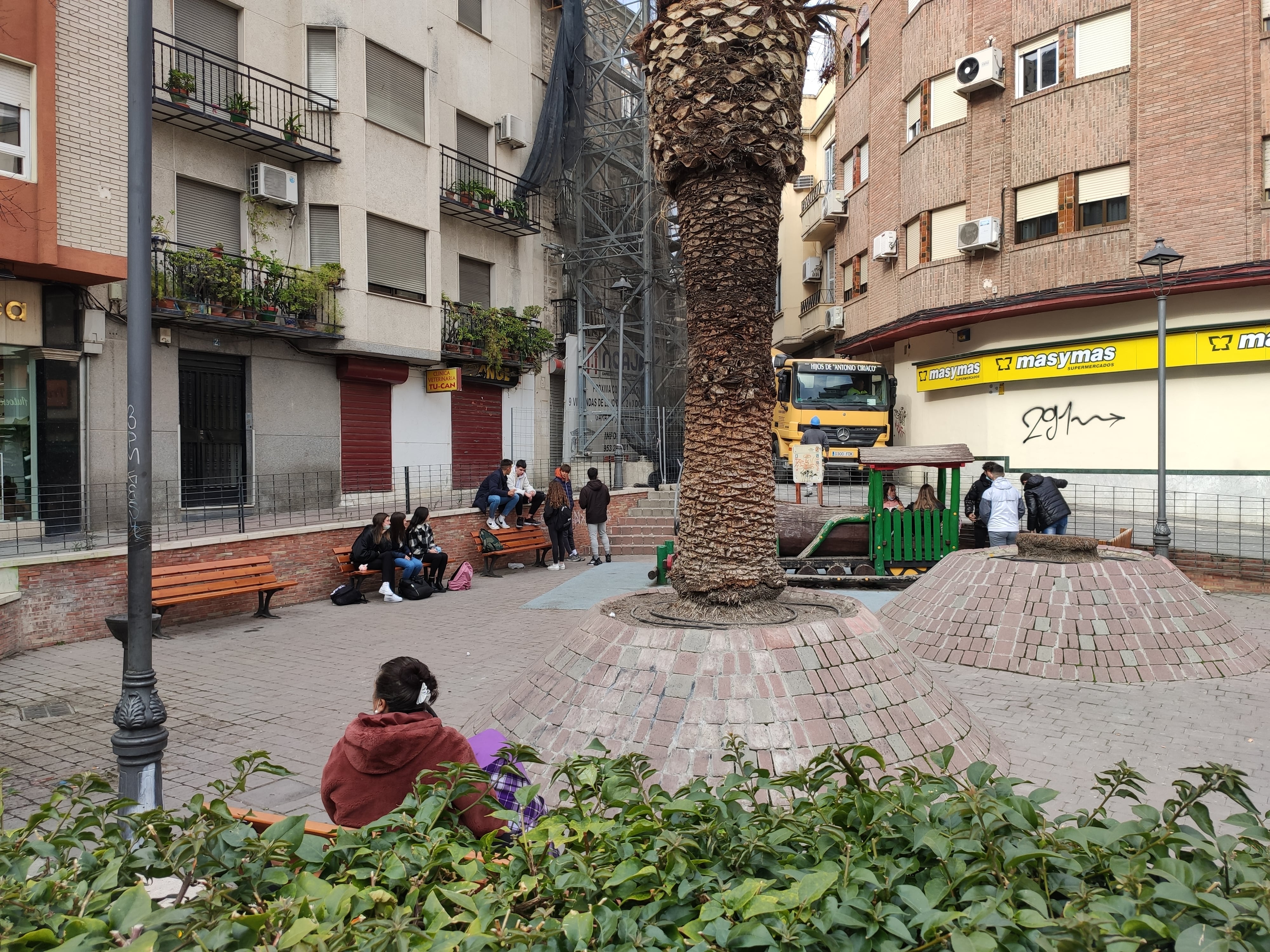 Personas sentadas alrededor de una plaza en el centro de Jaén capital