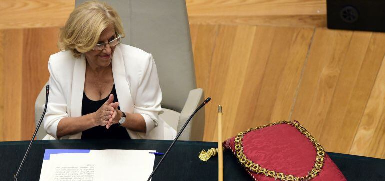 The new mayor of Madrid Manuela Carmena claps next to the Mayor&#039;s baton at the Cibeles Palace, City-Hall of Madrid, after being sworn in during the investiture session on June 13, 2015. The 71 year-old former judge Manuela Carmena, of the Indignados (Outraged) protester movement that grew out of Spain&#039;s economic crisis, was sworn in as mayor of Madrid today after unseating the conservative Popular Party, which has ruled the Spanish capital for nearly a quarter of a century.  AFP PHOTO / PIERRE PHILIPPE MARCOU