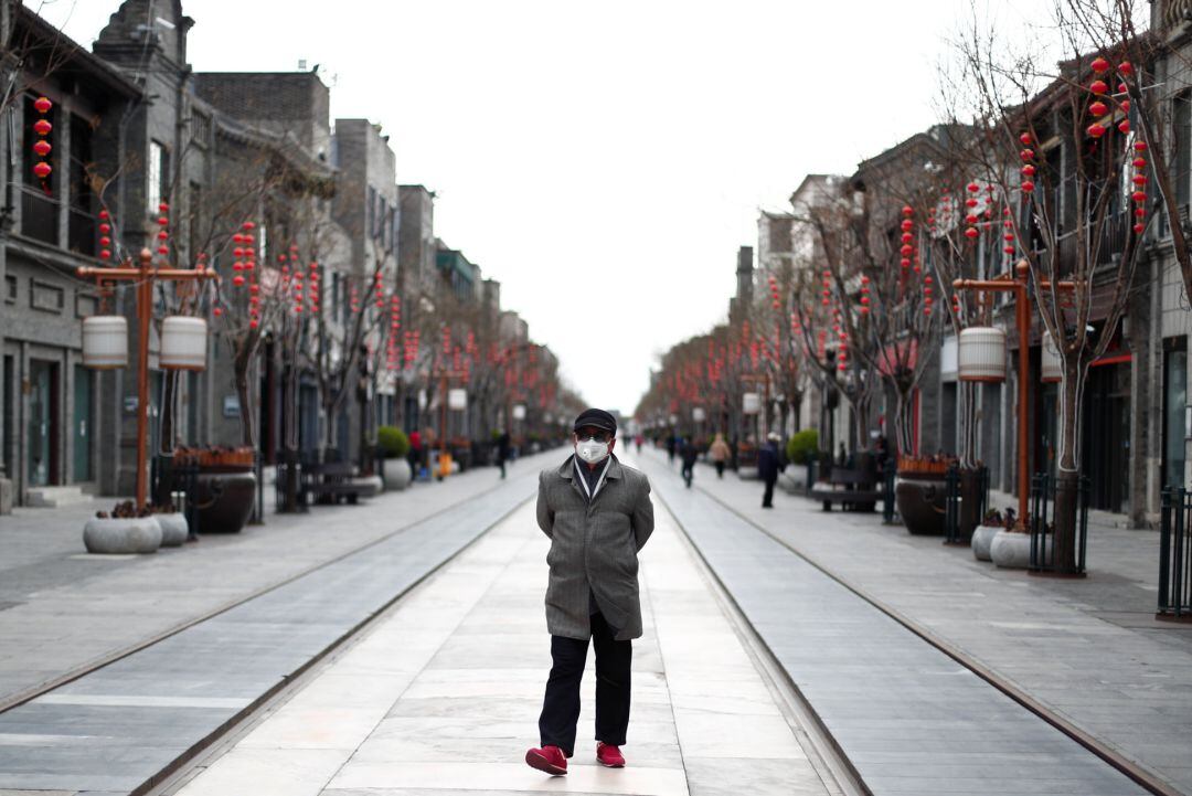 Un hombre pasea por Pekín con una máscara.