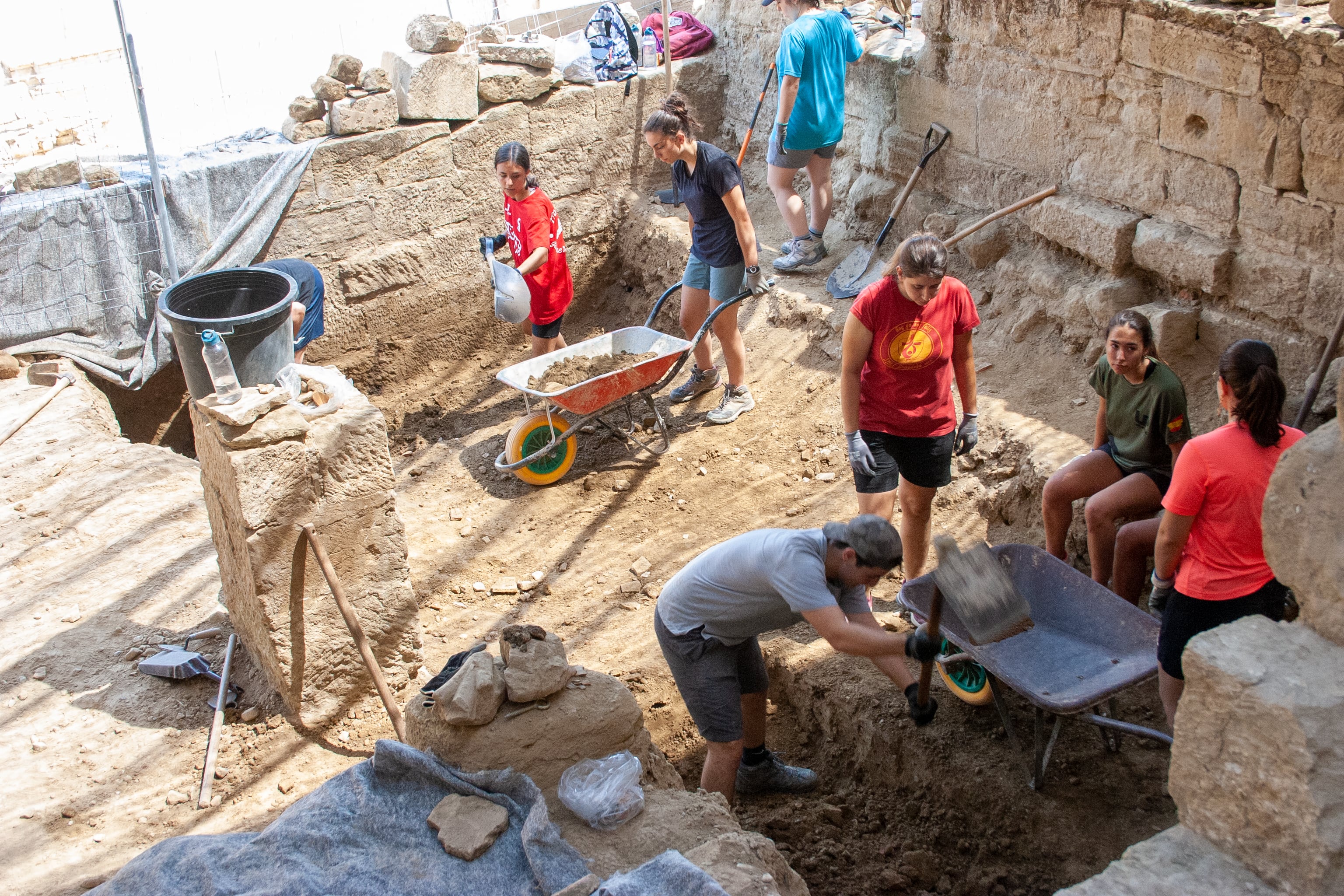 Jóvenes realizando labores de excavación en el campo de trabajo veraniego