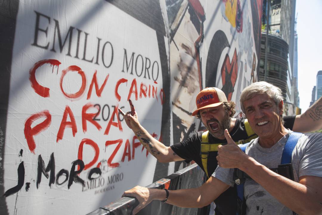 El bodeguero y el artista posan ante la imagen de la firma vitivinícola en el mural realizado en Times Square