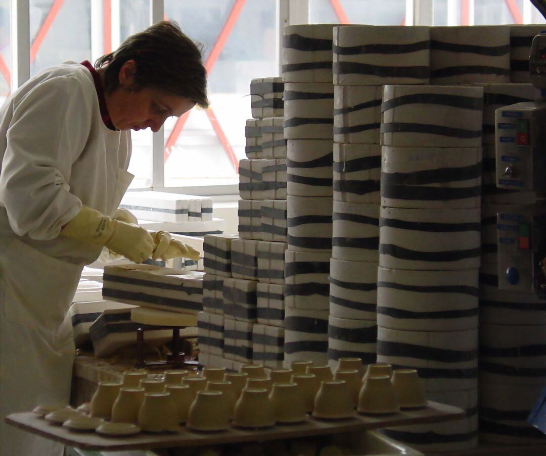 Trabajadora de Sargadelos manipula una cerámica.