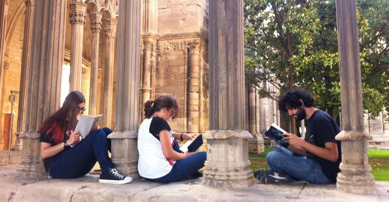 Tres joves llegint en un dels laterals del claustre considerat un dels més grans de l’arquitectura gòtica europea.