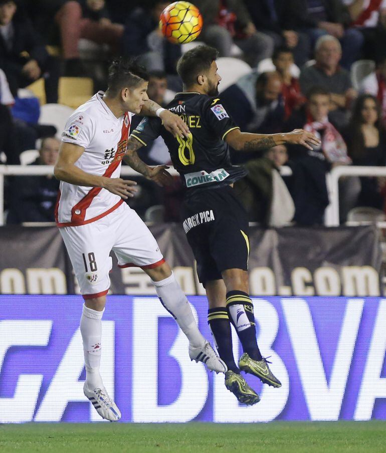 El defensa portugués del Rayo Vallecano Zé Castro (i) pelea un balón con el centrocampista del Granada Javi Márquez durante el partido de la undécima jornada de liga en Primera División que se disputa esta noche en el estadio de Vallecas.