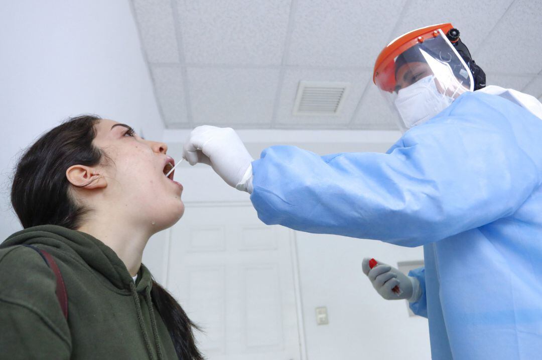 A health worker takes a sample for a PCR test
