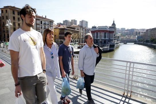 Idoia Mendia, acompañada de su marido Alfonso Gil, y sus hijos Álvaro (i) y Pablo, sale del mercado de La Ribera