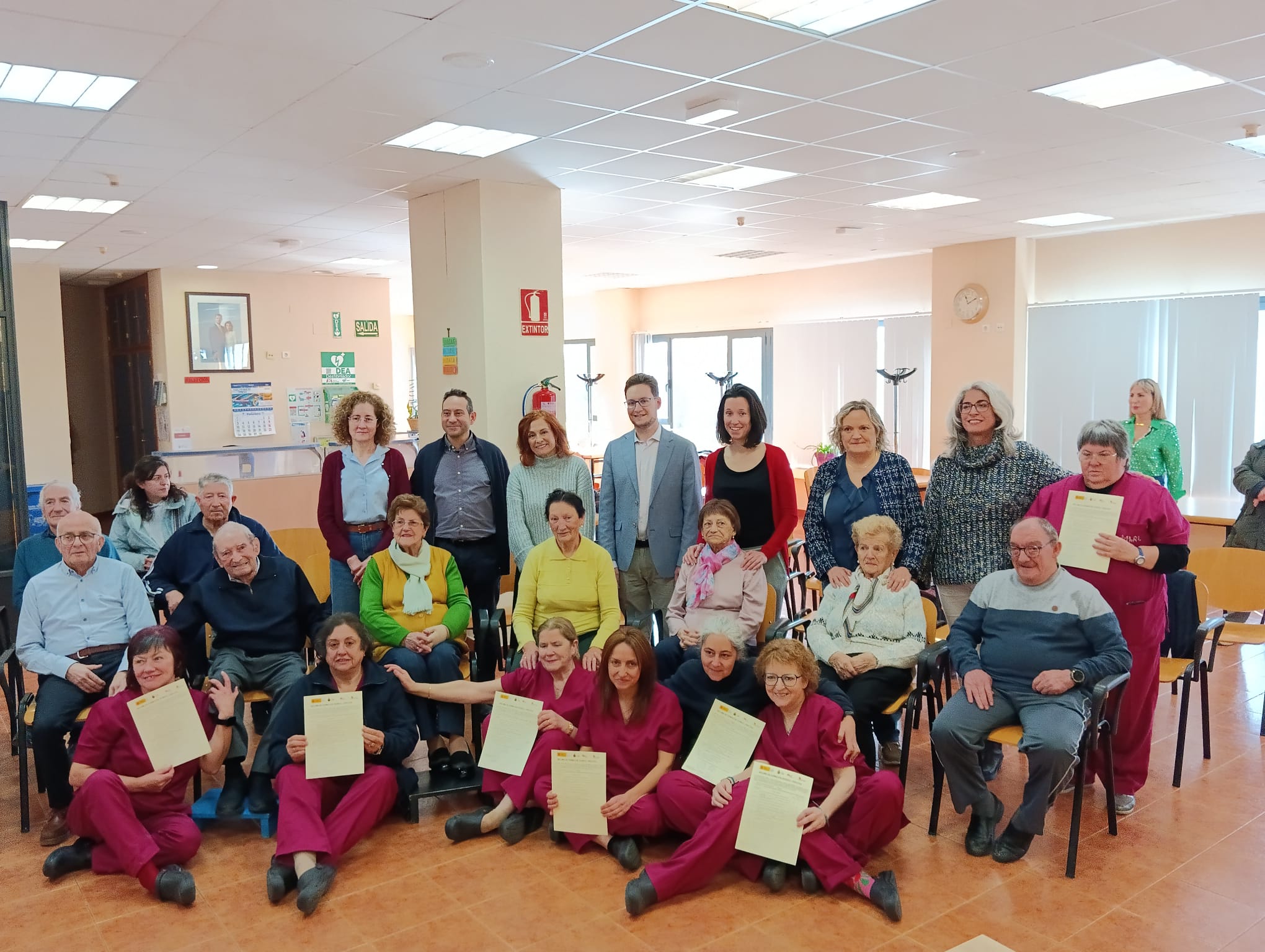 Alumnas y usuarios posan juntos en la entrega de diplomas, con las técnicos, monitoras y responsables políticos