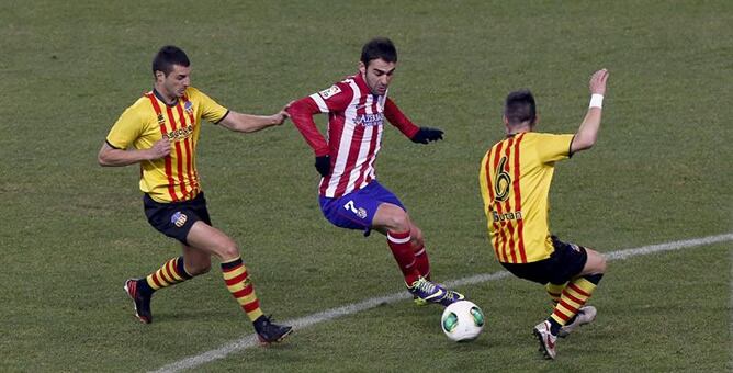 El delantero del Atlético de Madrid Adrián López intenta superar al portero del Sant Andreu José Miguel Morales  durante el partido de vuelta de dieciseisavos de final de la Copa del Rey de fútbol en el estadio Vicente Calderón.