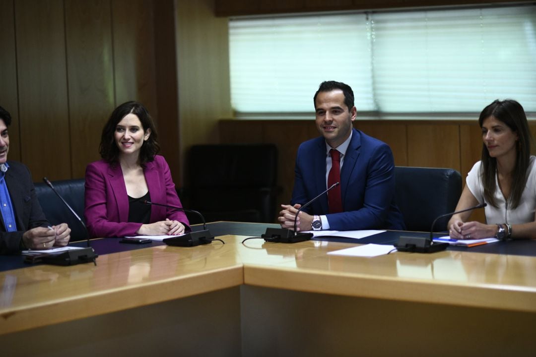 El candidato de Ciudadanos a la Presidencia de la Comunidad de Madrid, Ignacio Aguado (2d) y la candidata del PP, Isabel Díaz Ayuso (2i), durante sus negociaciones en la Asamblea de Madrid.