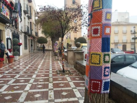 Algunos de los trabajos elaborados por el taller de bolillos de Jódar, en los árboles y el balcón principal del Ayuntamiento de Jódar