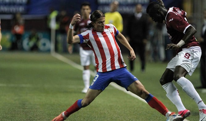 El jugador del Atlético de Madrid Filipe Luis disputa el balón con Jordan Hakeen, del Saprissa, el sábado 4 de agosto de 2012, durante un encuentro amistoso que se realiza en San José (Costa Rica).