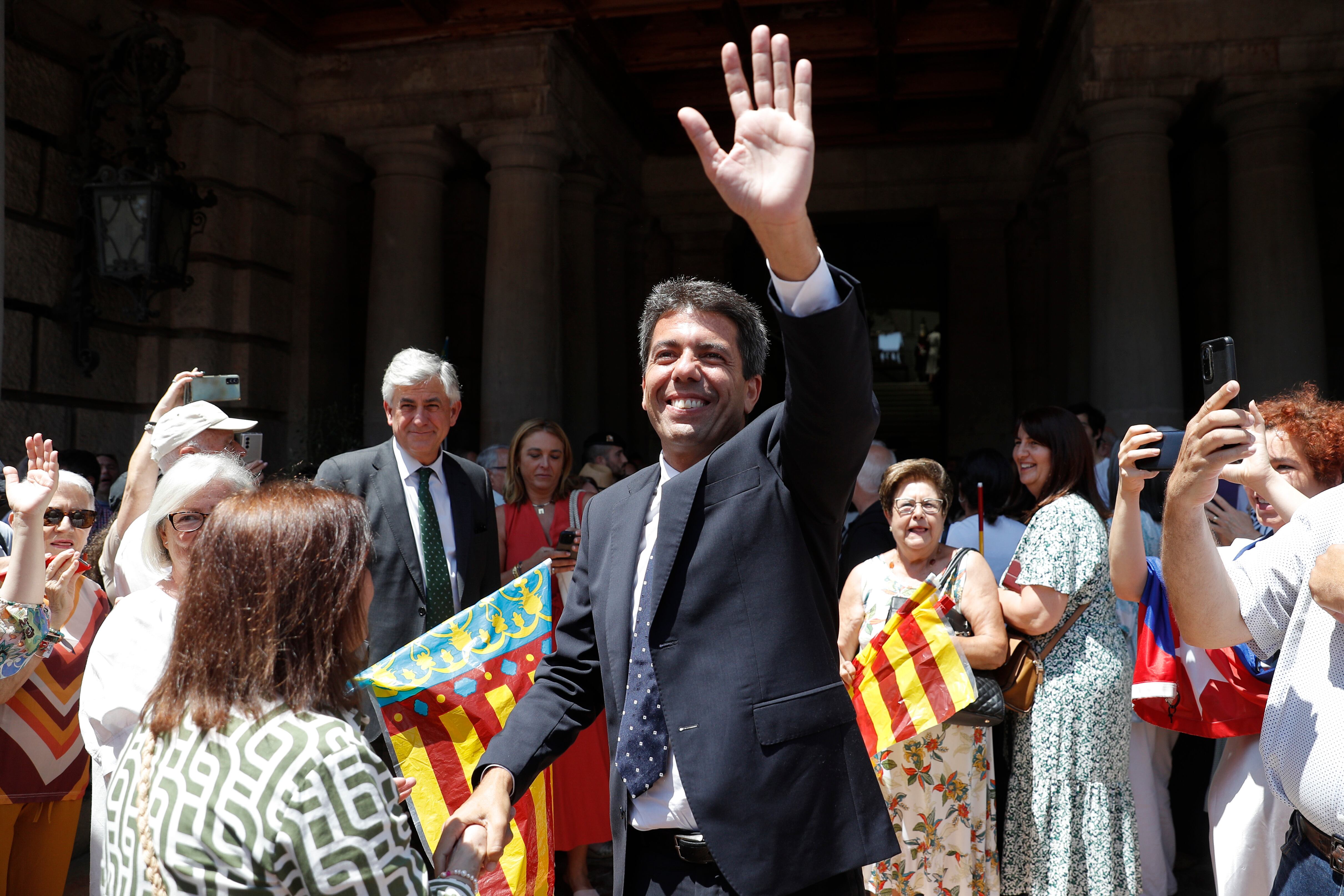 El proximo presidente de la Generalitat, el popular Carlos Mazón, saluda a la salida del Ayuntamiento de València donde fue investida nueva alcaldesa Maria José Catalá.