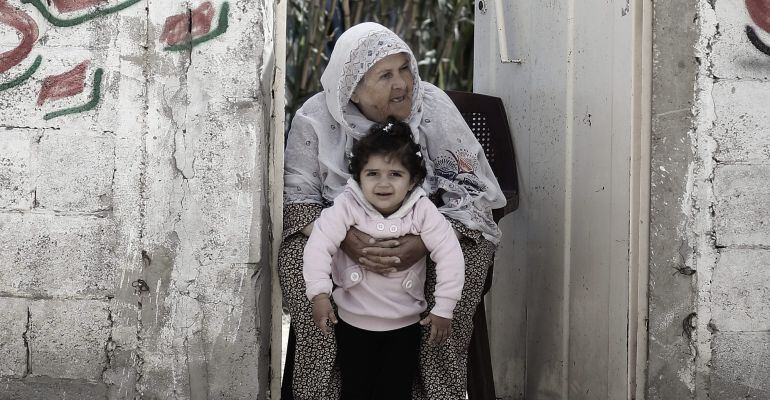 Una mujer sostiene a su nieta en el campo de refugiafos de Al Shateaa al norte de Gaza (Palestina)