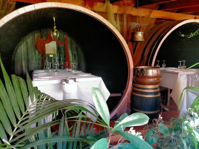 Unas grandes cubas de vino hacen de reservados en el restaurante.