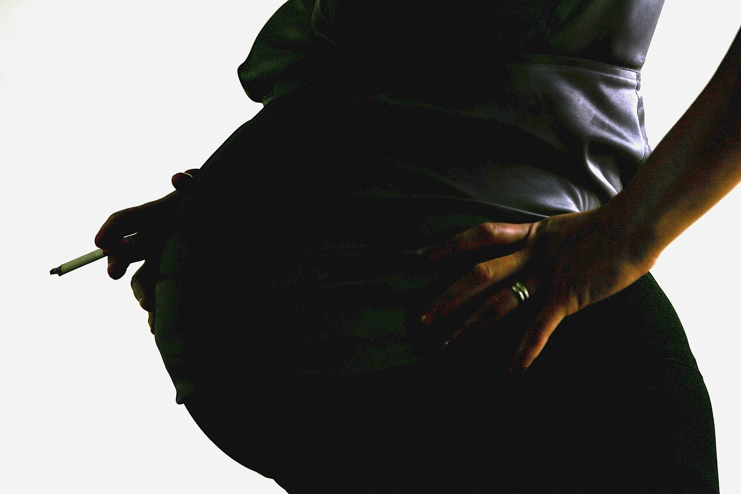 LONDON - JULY 18:  In this photo illustration a pregnant woman is seen holding a cigarette on July 18, 2005 in London, England. Research has shown that smoking during pregnancy damages a baby&#039;s airways before the child is born. (Photo illustration by Daniel Berehulak/Getty Images)