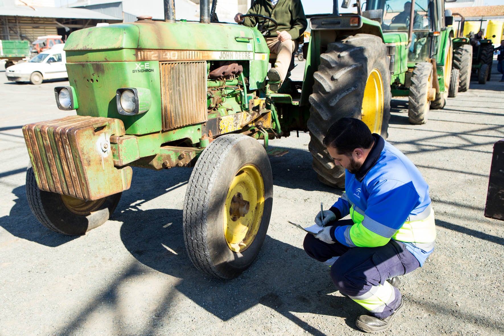 Un operario inspecciona un vehículo agrícola.