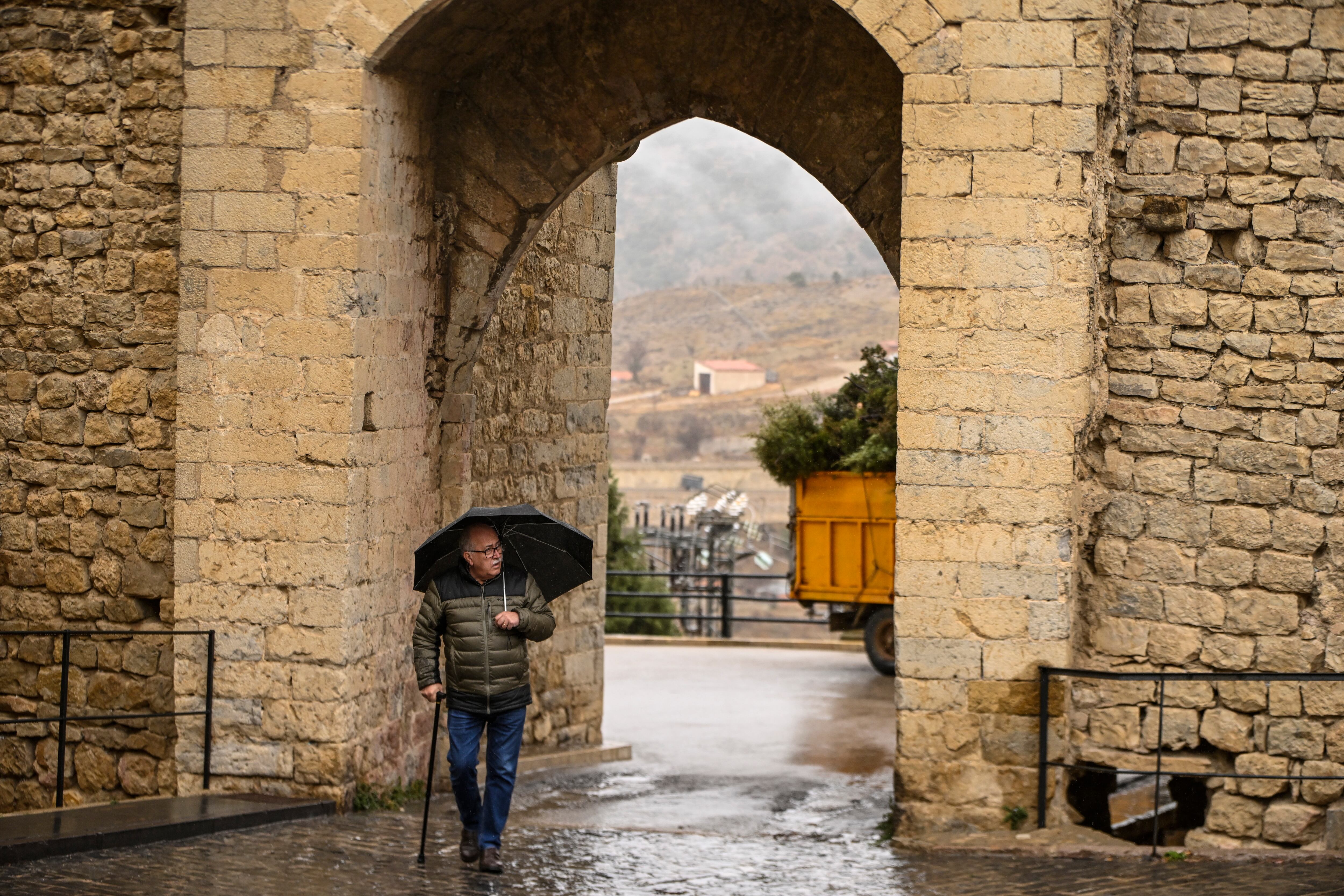 En la imagen de archivo de un hombre se protege con paraguas de la lluvia en Morella