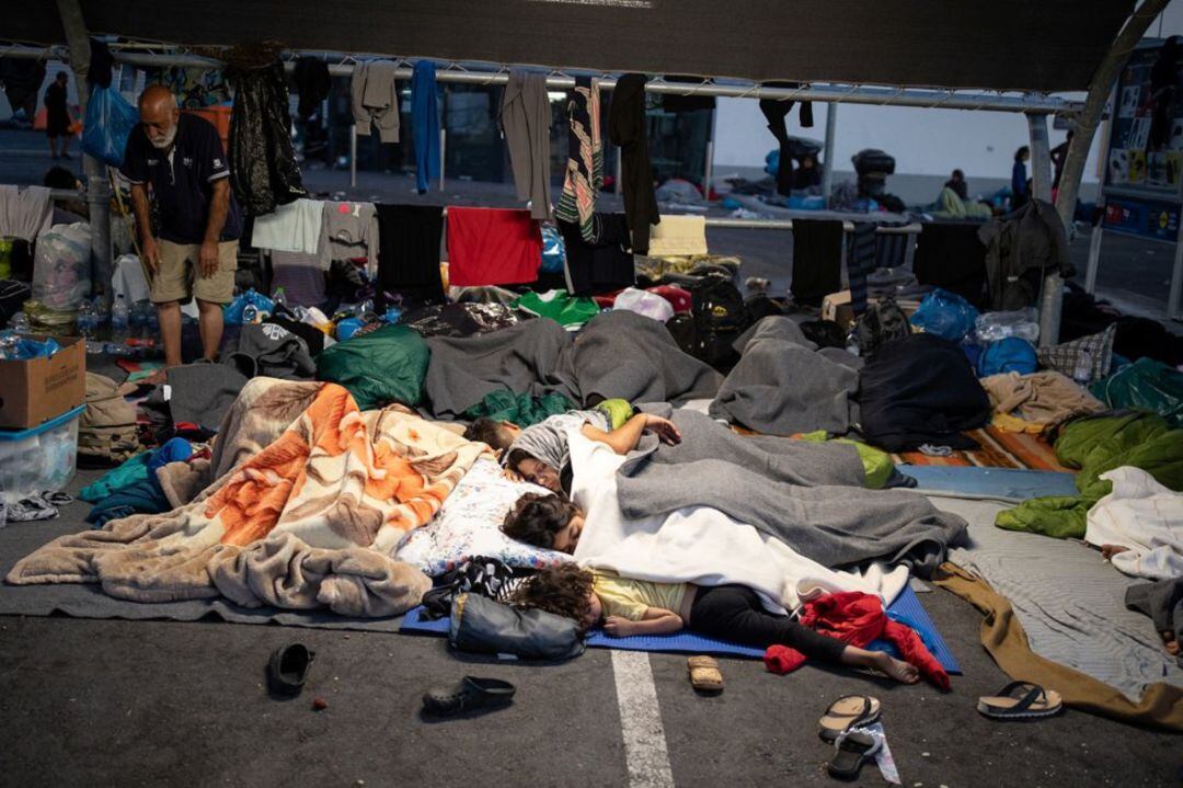 Migrantes y refugiados duermen en el parking cercano a un supermercado de Lesbos.