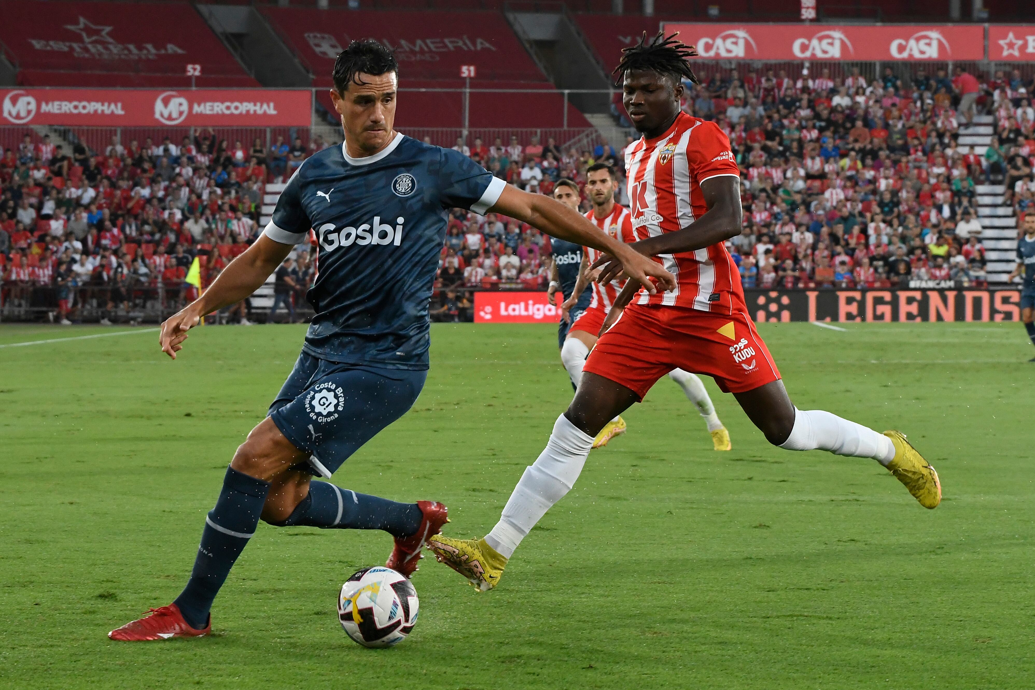 ALMERÍA, 20/10/2022.- El delantero maliense del Almería El Bilal Touré (d) disputa el balón ante Bernardo Espinosa (i), defensa colombiano del Girona, durante el partido de la décima jornada de LaLiga entre la UD Almería y el Girona FC, este jueves en el Power Horse Stadium de Almería. EFE / Carlos Barba