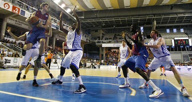 El alero del F.C. Barcelona Regal Xavi Rabaseda se dispone a pasar el balón a su compañero senegalés Boniface Ndong ante los jugadores del Lucentum Alicante Mohamed Kone y Álex Urtasun