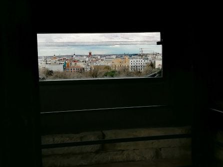 Uno de los ventanales del mirador del monumento a Alfonso XII con las vistas de la línea del horizonte de Madrid a lo lejos