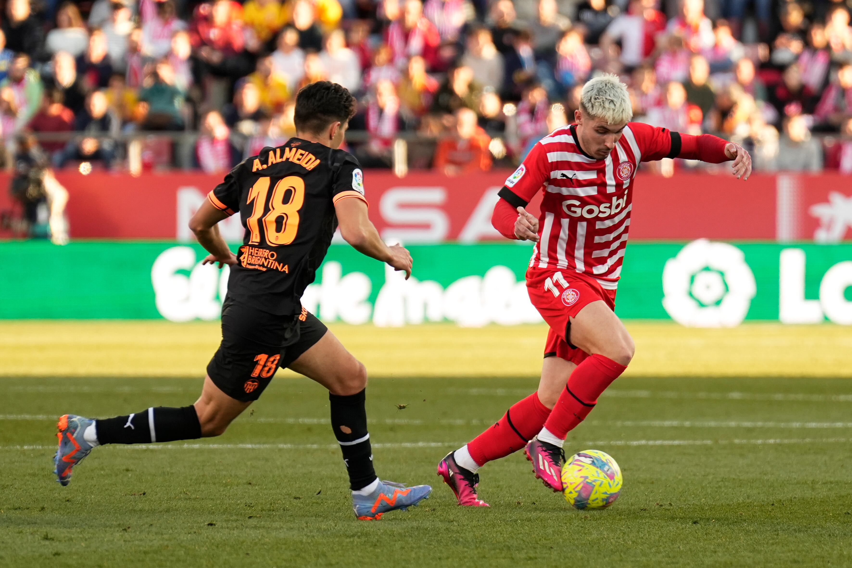 Girona, 05/02/2023. El centrocampista del Valencia, André Almeida (i), disputa un balón con Valery Fernández, delantero del Girona durante el partido de LaLiga Santander que se disputa este domingo entre Girona FC - Valencia CF, en el estadio municipal de Montilivi de Girona. EFE/David Borrat