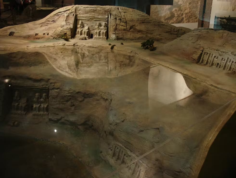 Maqueta que muestra la ubicación original de los templos de Abu Simbel del siglo XIII a. e. c., el lugar sumergido bajo el agua de un embalse desde la década de 1970 y los nuevos emplazamientos más altos de los templos rescatados y reubicados. La foto fue tomada en una exposición del Museo Nubio de Asuán (Egipto).