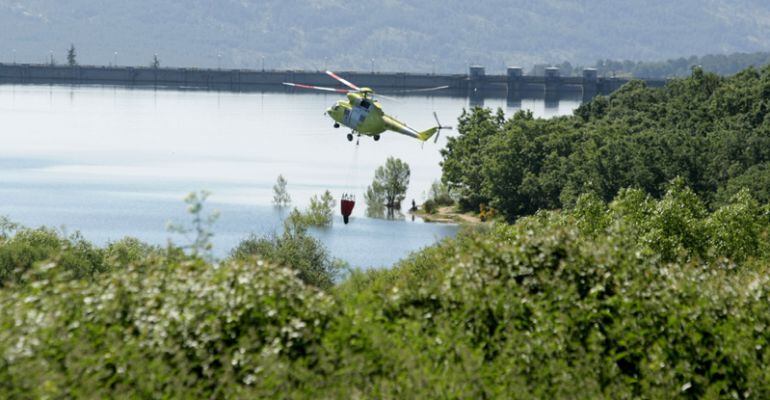 Helicóptero recogiendo agua durante la extinción de un incendio