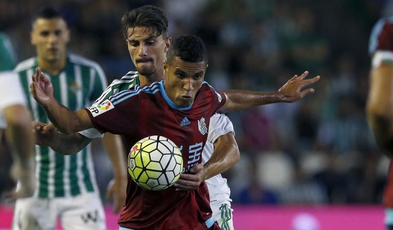 GRA472. SEVILLA, 12/09/2015.- El delantero brasileño de la Real Sociedad, Jonathas (delante), intenta controlar el balón ante el acoso del defensa italiano del Betis, Cristiano Piccini, durante el encuentro correspondiente a la tercera jornada de primera división, que disputan esta noche en el estadio Benito Villamarín de Sevilla. EFE/Julio Muñoz.