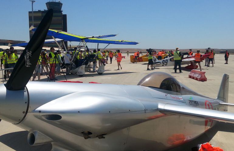 Imatge d'una de les avionetes participants en la cursa, amb el fons de la torre de l'Aeroport de Lleida-Alguaire