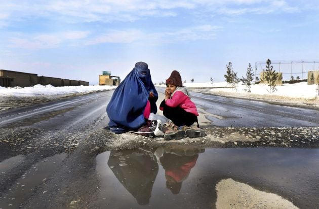 Una mujer y una niña afganas piden limosna en una calle de Kabul, Afganistán