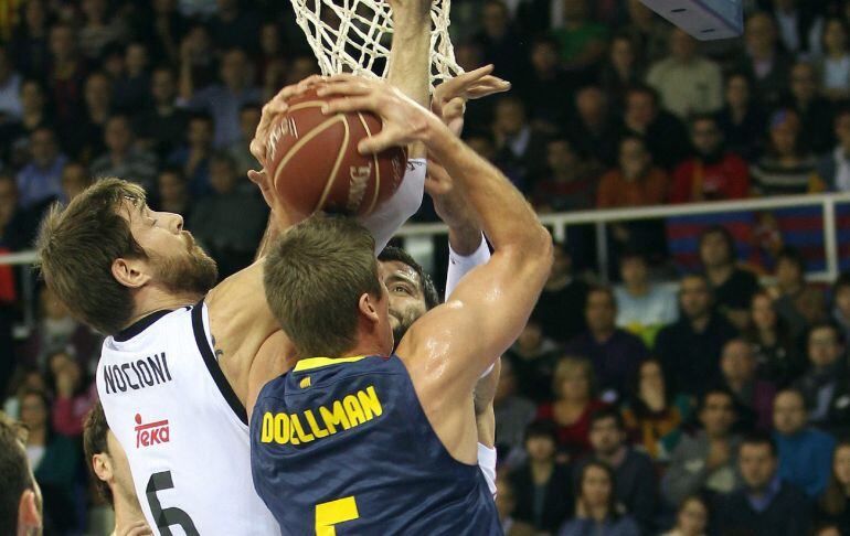 El ala pivot estadounidense del Barcelona Justin Doellman entra a canasta ante el ala pivot argentino del Real Madrid, Andrés Nocioni.