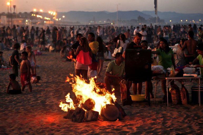 VALENCIA, Un grupo de personas prepara una barbacoa junto a una hoguera, esta noche en la playa de la Malvarrosa de Valencia, donde cada noche de San Juan miles de personas se acercan hasta la orilla del mar para saltar sobre el fuego y las olas.