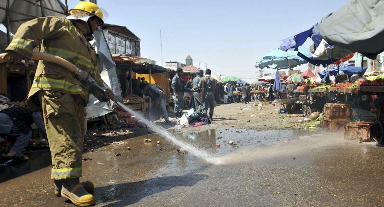 Bomberos limpian la calle en el mercado de Mazar-i-Sharif, donde se ha producido el atentado.