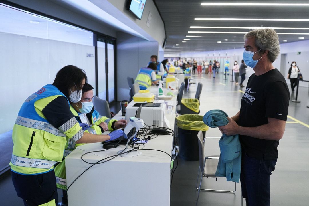 Un hombre espera para ser registrado, después de recibir la dosis con la vacuna de Pfizer en el Wanda Metropolitano