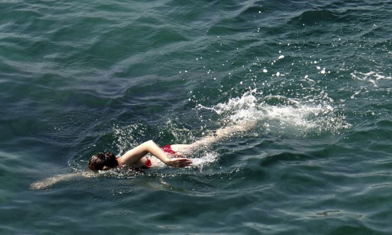 Una mujer nada en el mar Mediterráneo. 