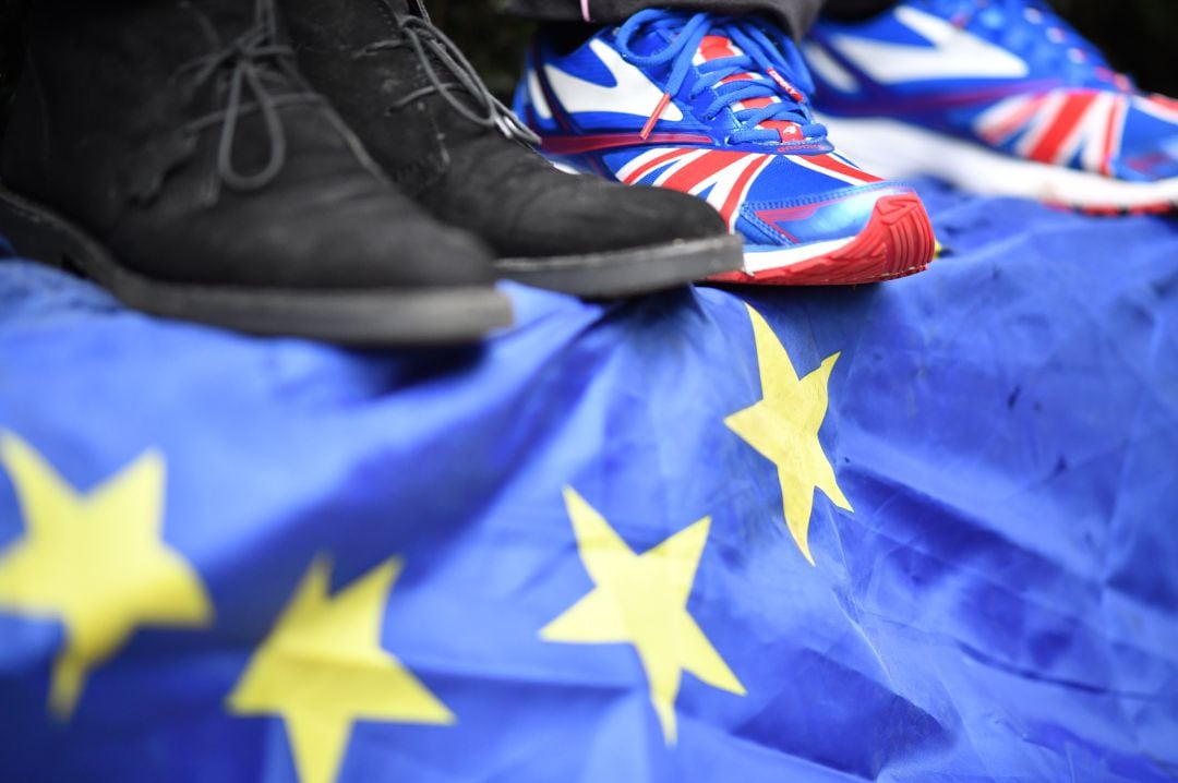 Manifestantes pisan una bandera de la Unión Europea.