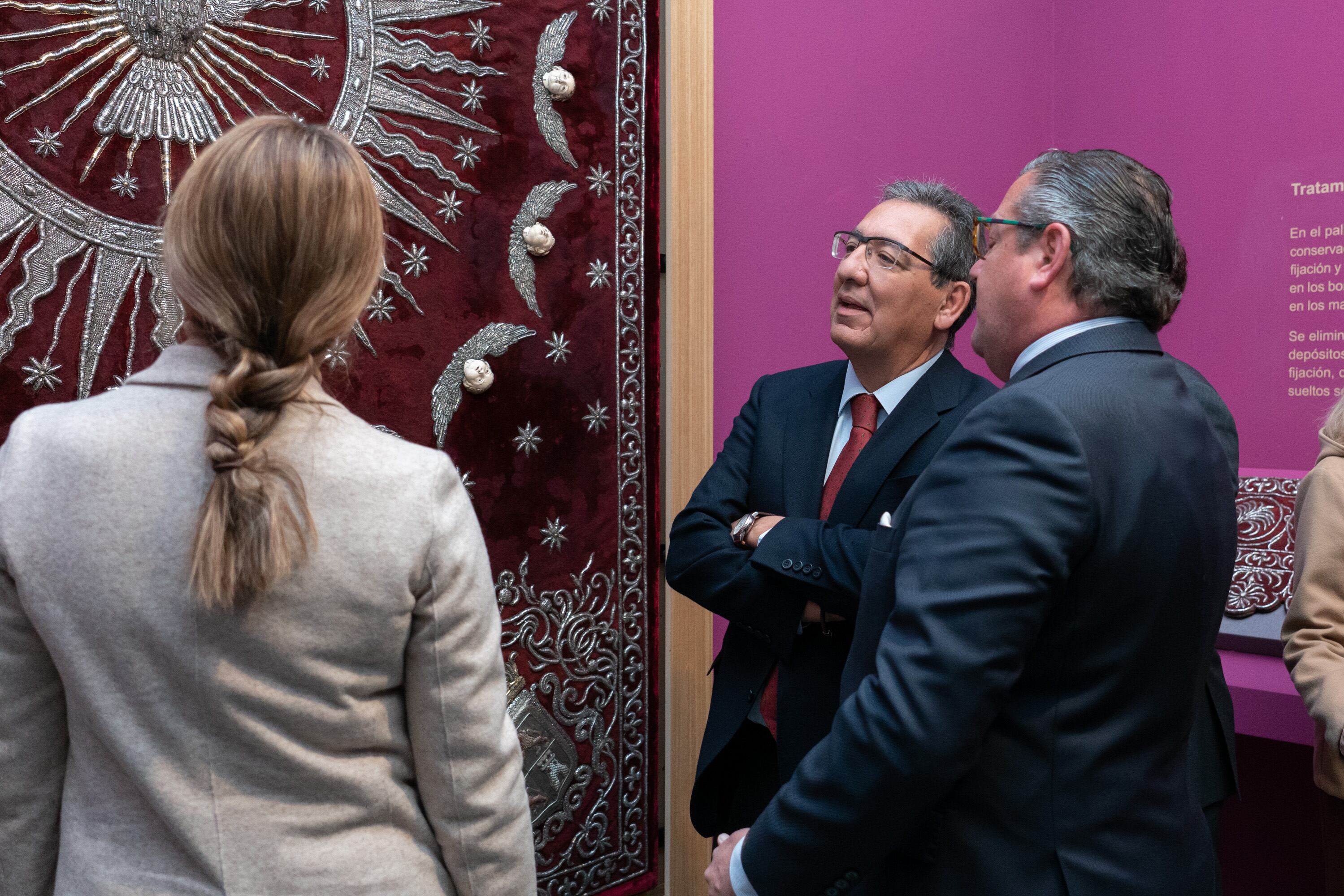 Antonio Pulido, presidente de la Fundación Cajasol, contempla el palio del Valle junto al hermano mayor de la cofradía y la delegada provincial de Cultura