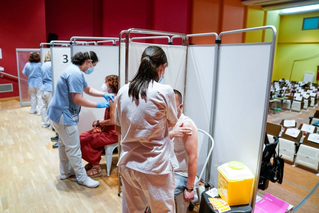 Dos personas reciben la primera dosis de la vacuna de Pfizer-BioNTech contra el Covid-19 en el Hospital Severo Ochoa de Leganés, Leganés.