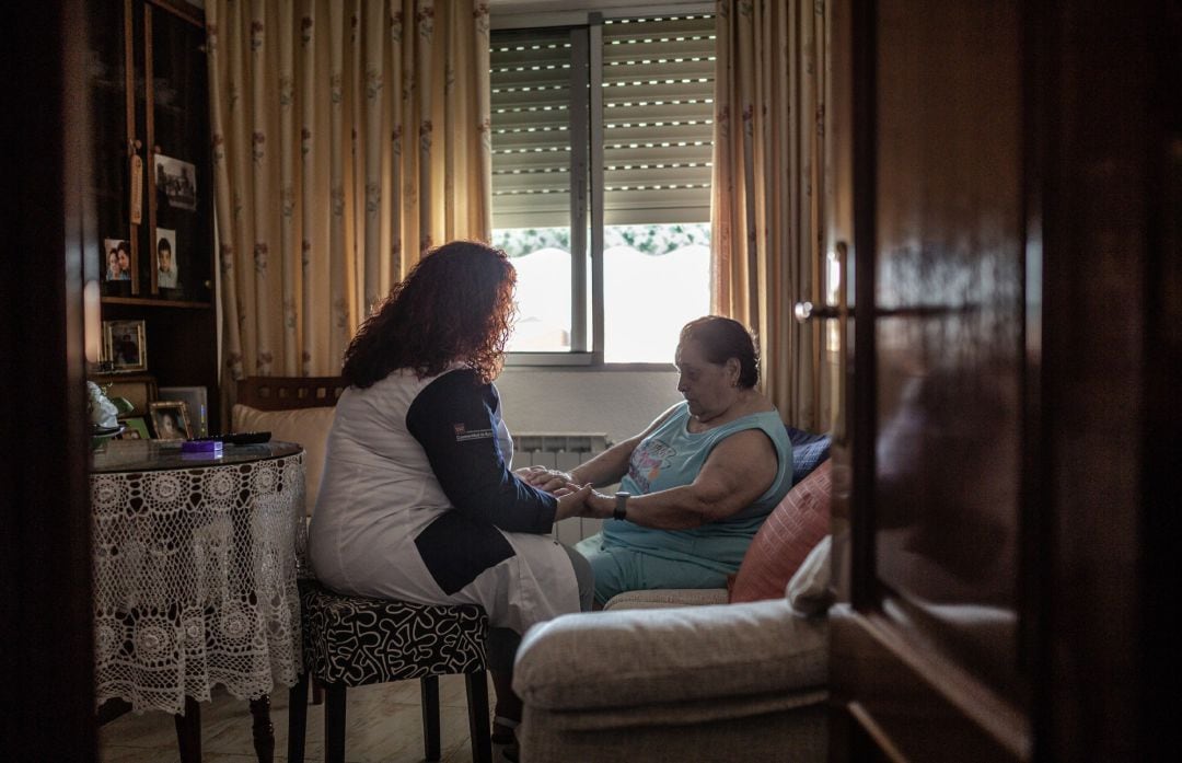Una auxiliar de asistencia a domicilio cuida de una mujer mayor en situación de dependencia.