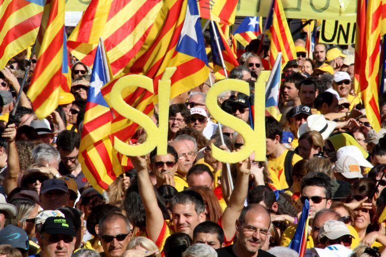 Un noi aguanta un doble sí en al·lusió a la pregunta consensuada per la consulta en una manifestació a Plaça Catalunya