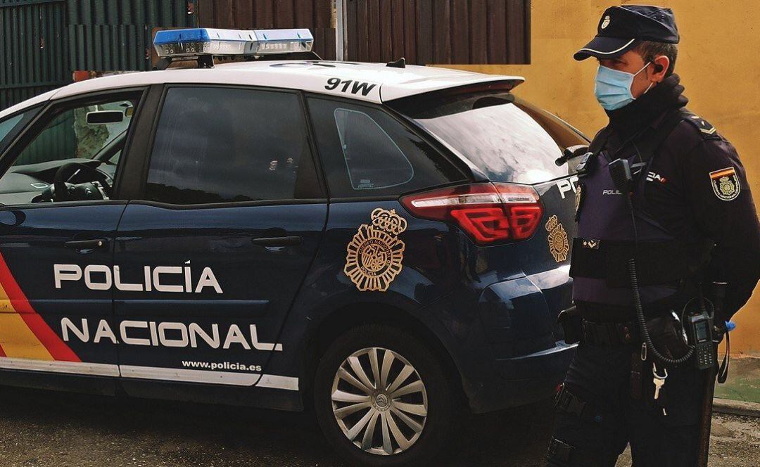 Un policía nacional junto a unidad móvil.