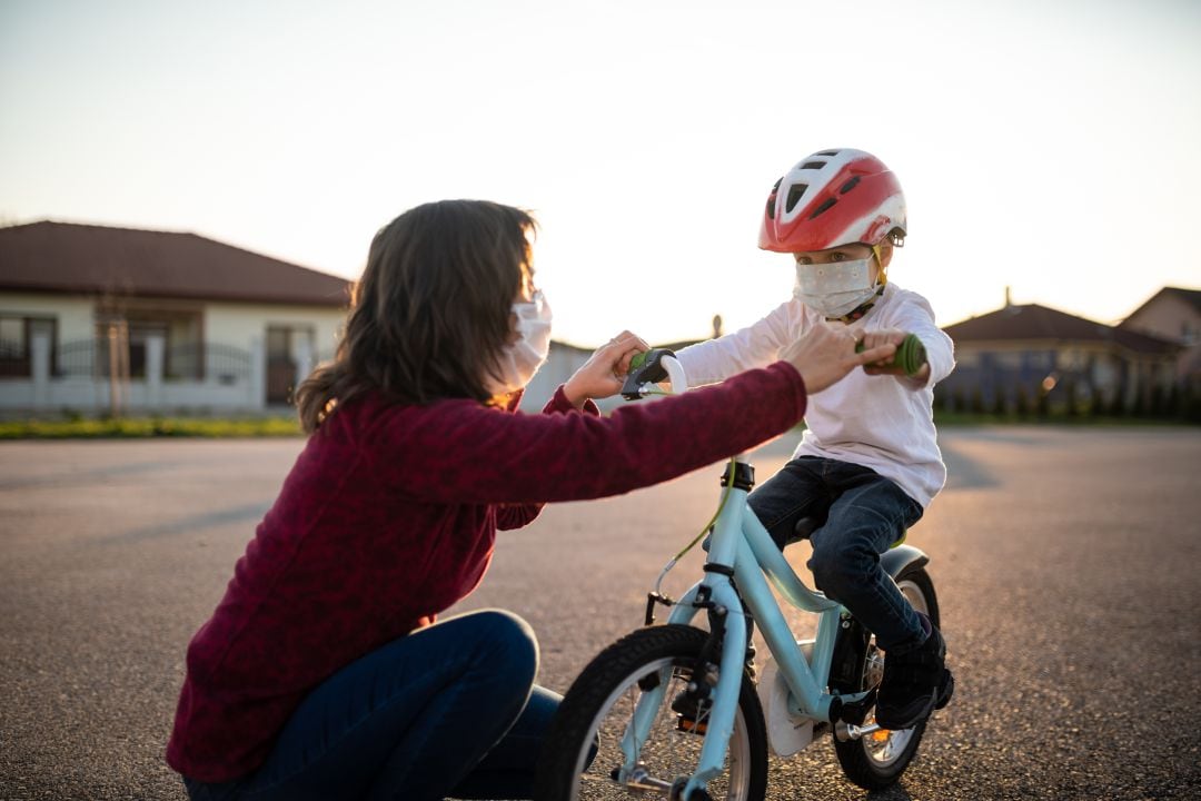 Un niño aprende a montar en bicicleta con su madre