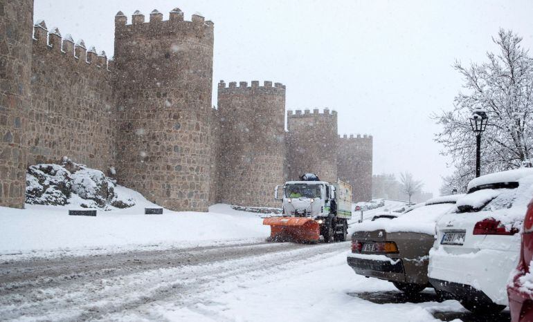 Una máquina quitanieves trabaja para retirar la nieve caída junto a la muralla de Ávila el pasado fin de semana.