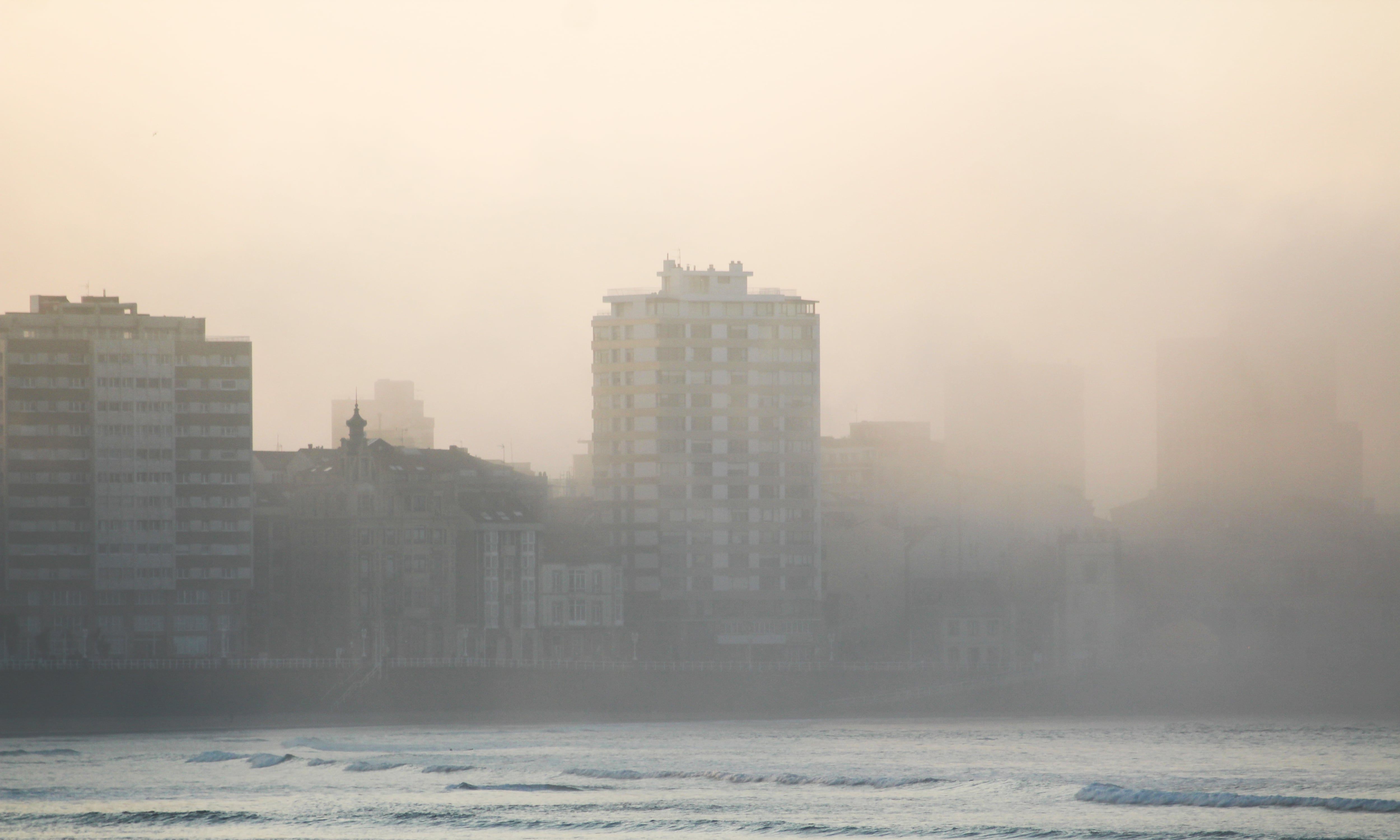 Gijón, Asturias, Spain - February 26, 2019: The city of Gijón from the beach of San Lorenzo on a foggy day at sunset, Asturias province, north of Spain.
